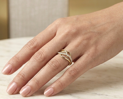 18K yellow gold interwoven diamond ring featuring flowing crossover bands and 0.22 carats of natural round brilliant diamonds.