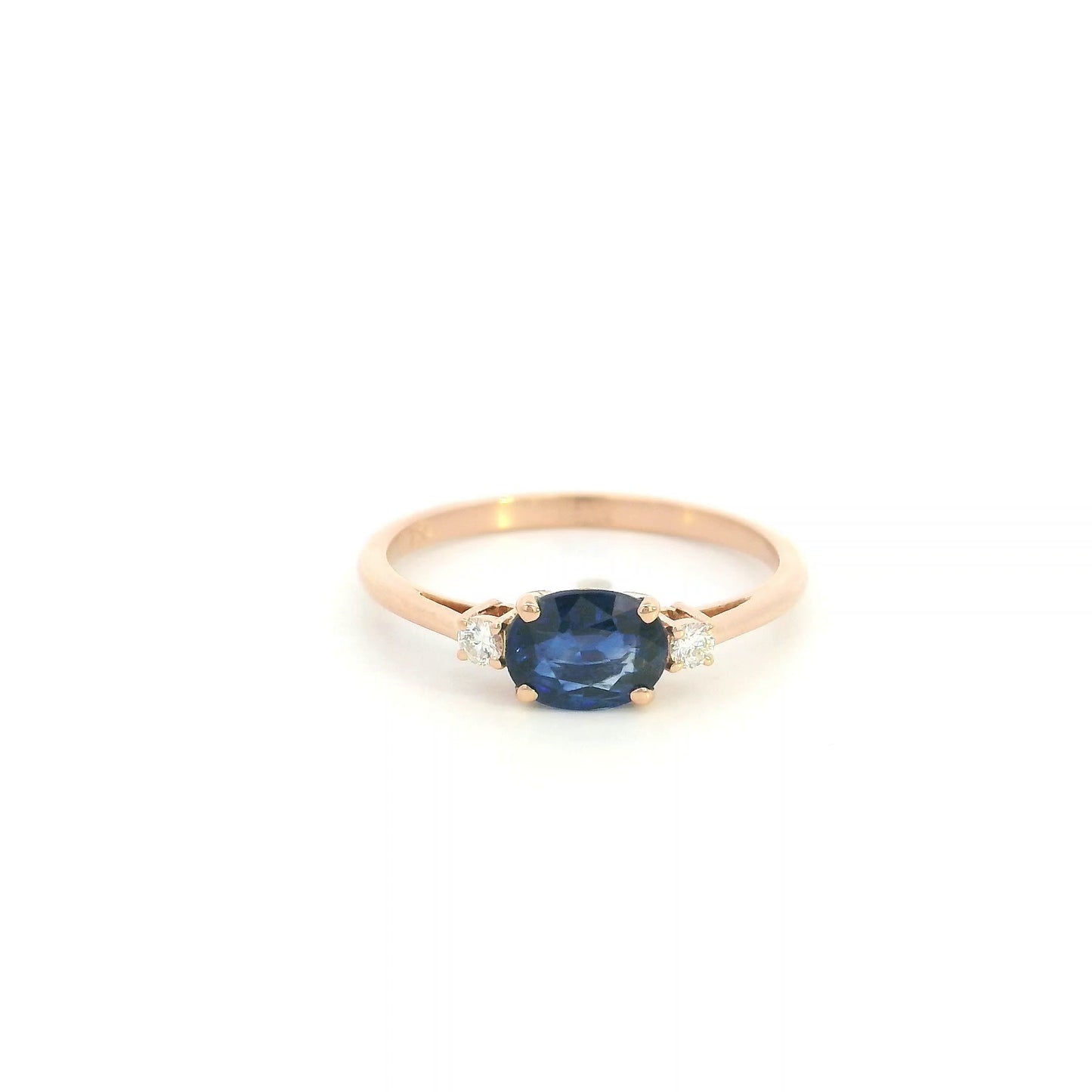 18K rose gold oval blue sapphire ring featuring a 1.06 Carat natural sapphire with round natural diamond side stones.