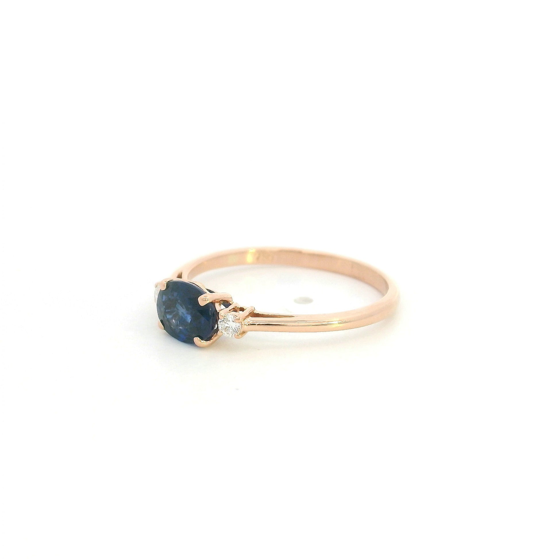 18K rose gold oval blue sapphire ring featuring a 1.06 Carat natural sapphire with round natural diamond side stones.