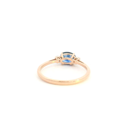 18K rose gold oval blue sapphire ring featuring a 1.06 Carat natural sapphire with round natural diamond side stones.