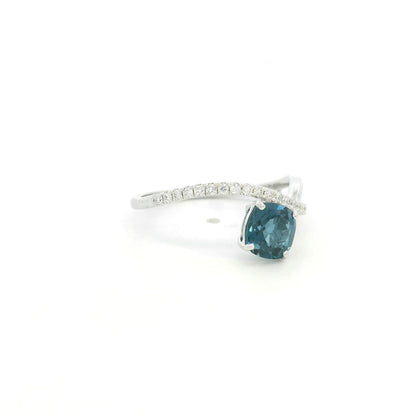 18K white gold twist ring featuring a 1.10 carat natural cushion-cut London Blue Topaz with a diamond-set crossover band and 0.15 carat natural diamonds.
