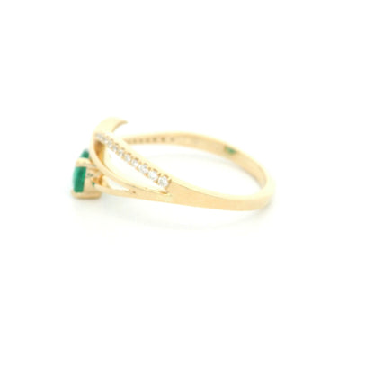 18K yellow gold emerald crossover ring featuring a 0.51 carat natural emerald and 0.09 carat natural diamond accent band.