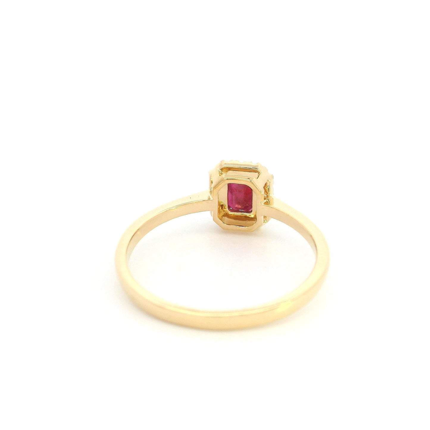 Ruby and diamond halo ring in 18K yellow gold with rectangular red ruby, round diamond surround and polished gold band.