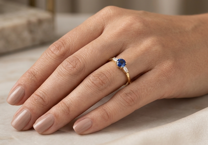 Round blue sapphire and baguette diamond three stone ring in 18K yellow gold