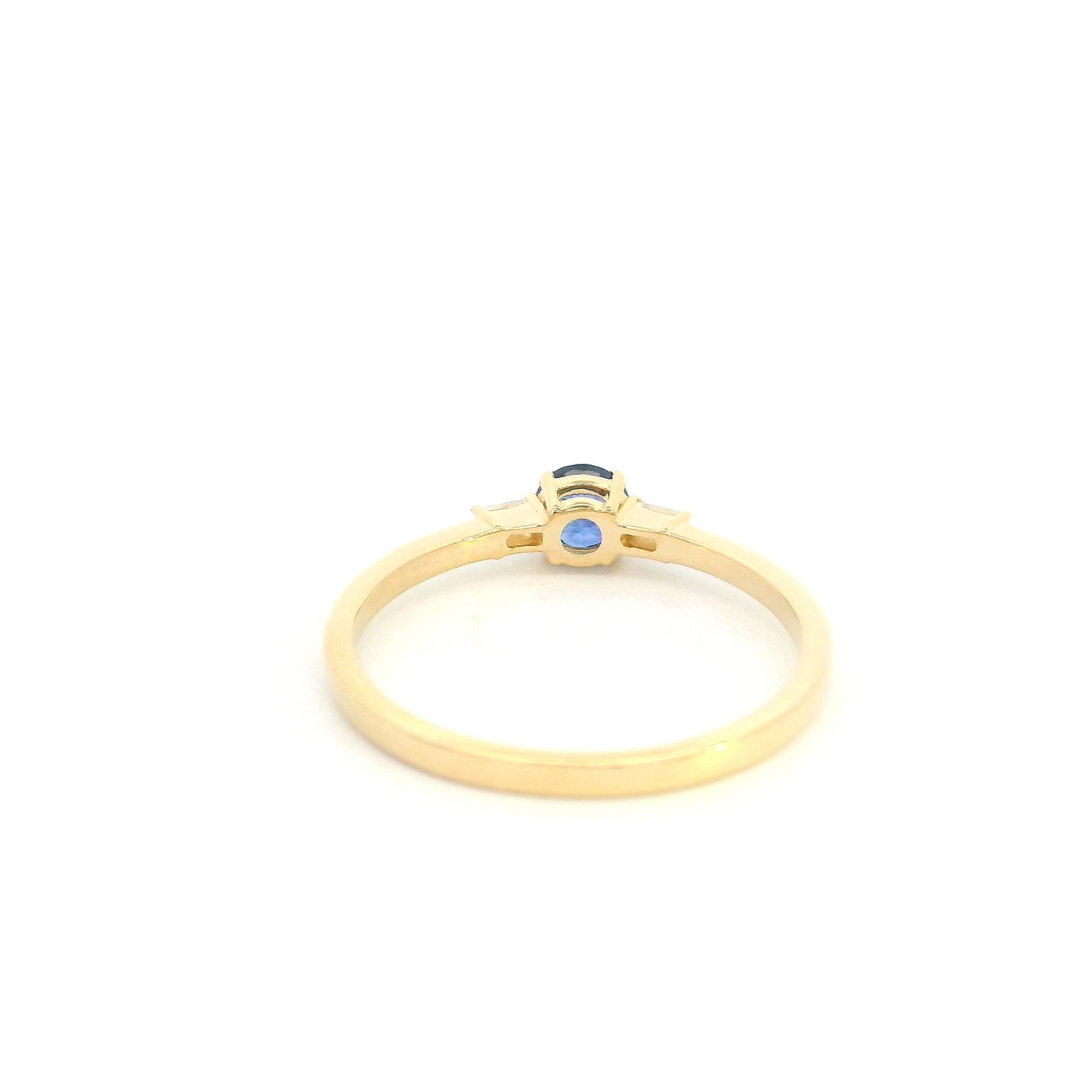 Round blue sapphire and baguette diamond three stone ring in 18K yellow gold