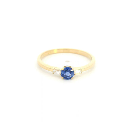 Round blue sapphire and baguette diamond three stone ring in 18K yellow gold