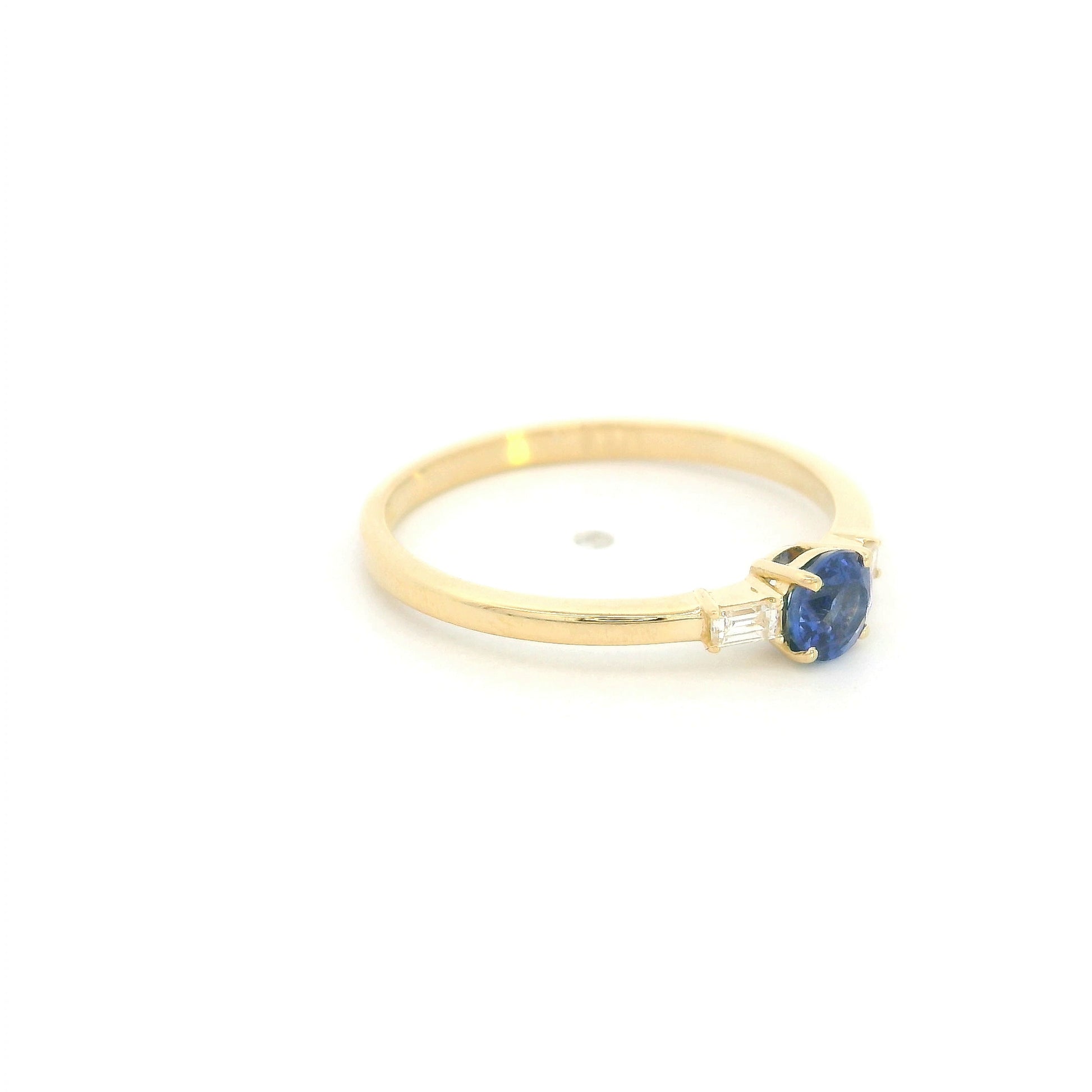 Round blue sapphire and baguette diamond three stone ring in 18K yellow gold