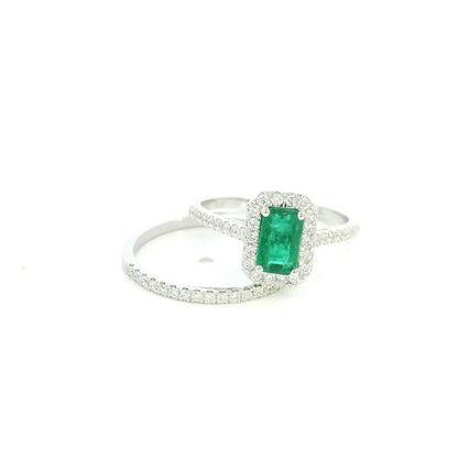 18K white gold emerald bridal set featuring a 0.71 carat natural emerald-cut emerald with a diamond halo and matching diamond wedding band.