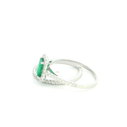 18K white gold emerald bridal set featuring a 0.71 carat natural emerald-cut emerald with a diamond halo and matching diamond wedding band.