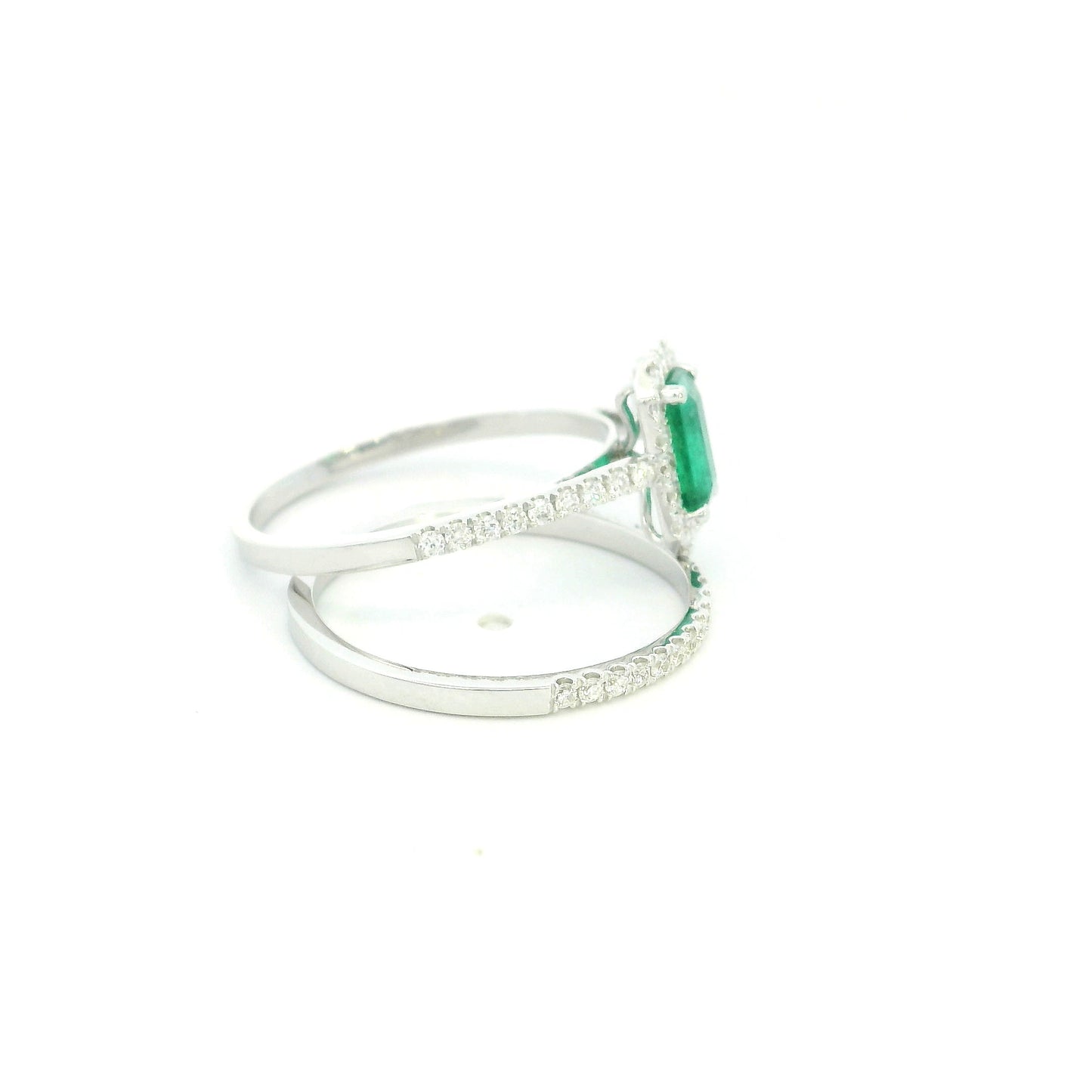 18K white gold emerald bridal set featuring a 0.71 carat natural emerald-cut emerald with a diamond halo and matching diamond wedding band.