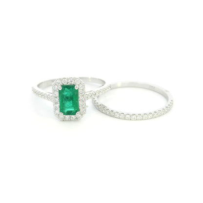 18K white gold emerald bridal set featuring a 0.71 carat natural emerald-cut emerald with a diamond halo and matching diamond wedding band.
