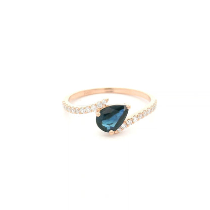 Natural pear-shaped blue sapphire ring in 18K rose gold featuring a 0.78 carat blue sapphire with a bypass diamond band set with 0.19 carat natural diamonds.