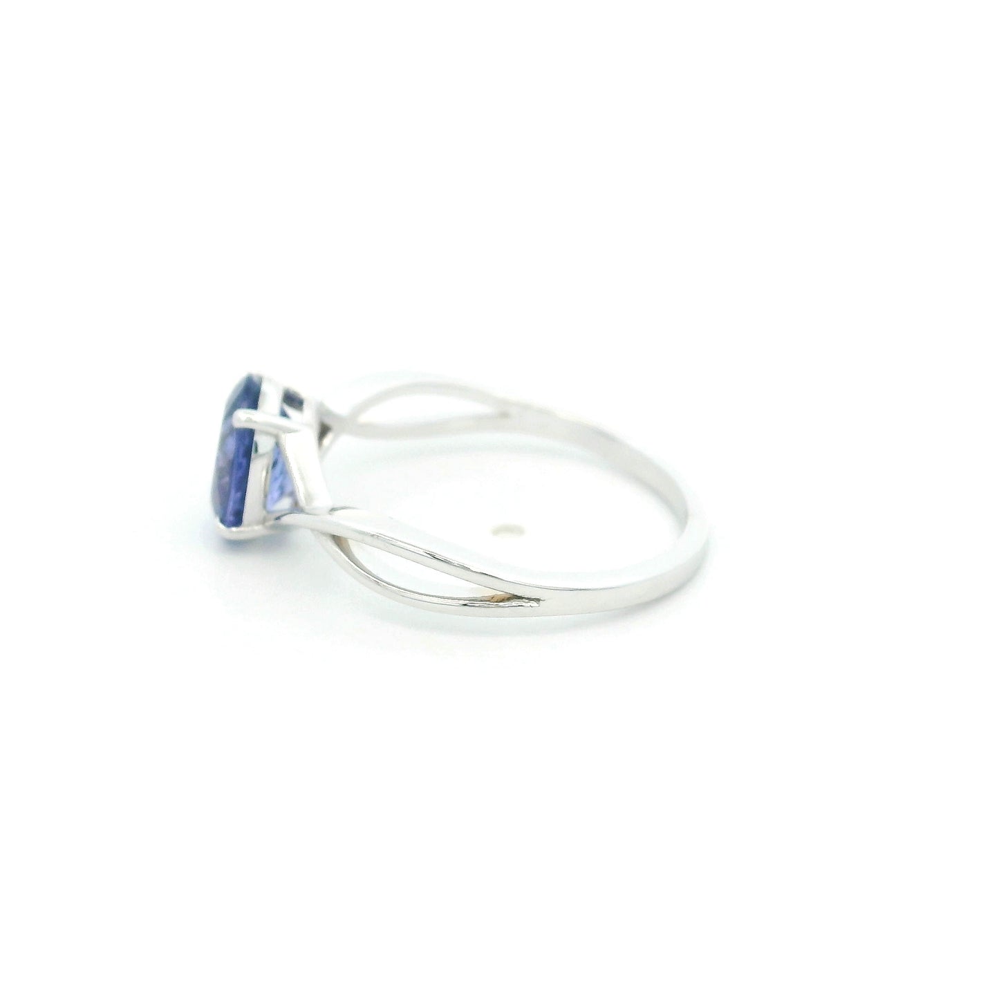 Oval tanzanite solitaire ring with sculptural crossover band in 18K white gold.