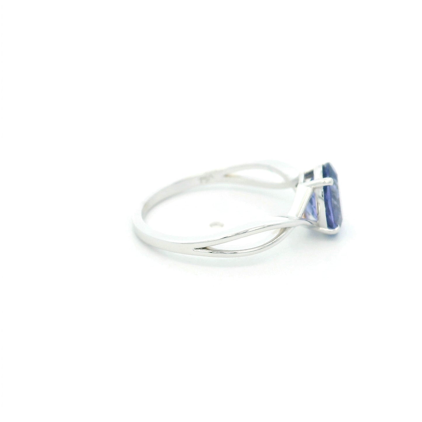 Oval tanzanite solitaire ring with sculptural crossover band in 18K white gold.
