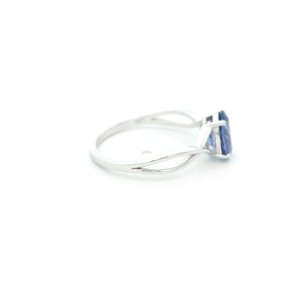 Oval tanzanite solitaire ring with sculptural crossover band in 18K white gold.