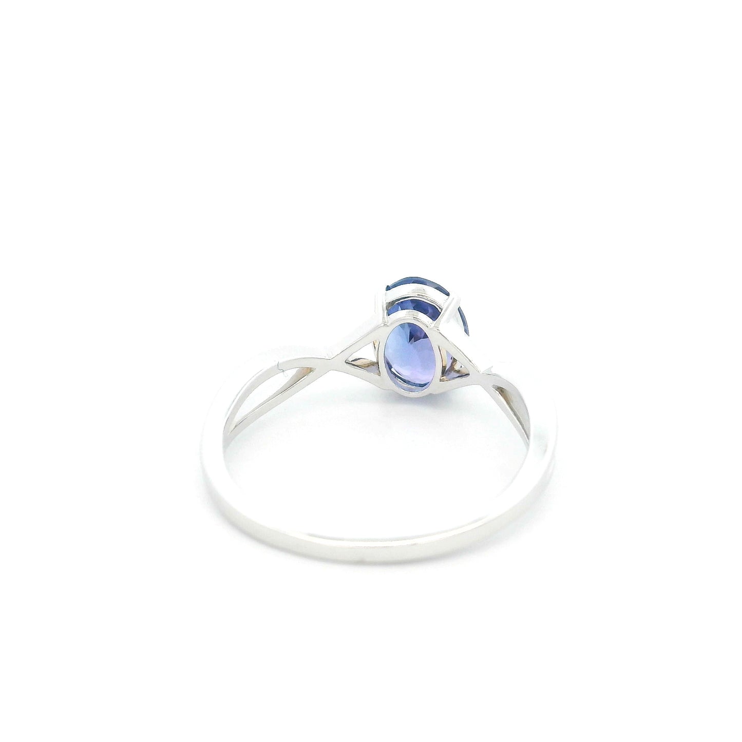 Oval tanzanite solitaire ring with sculptural crossover band in 18K white gold.