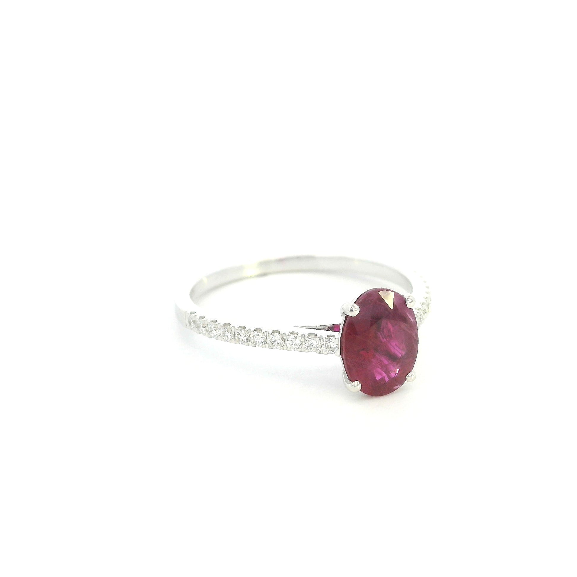 Ruby diamond ring in 18K white gold featuring a natural 1.32 carat oval-cut ruby with a diamond-set band.