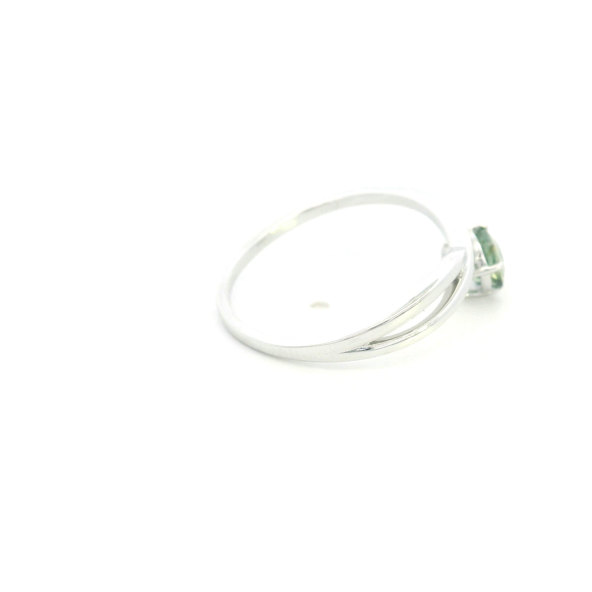 18K white gold crossover ring featuring a natural 0.88 carat round green sapphire in a contemporary solitaire design.