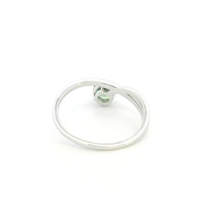 18K white gold crossover ring featuring a natural 0.88 carat round green sapphire in a contemporary solitaire design.
