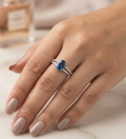 Natural London Blue Topaz ring in 18K white gold featuring a 2.22 carat oval London Blue Topaz with a split shank and 0.36 carat natural diamond band.