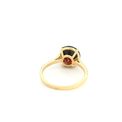 Garnet diamond ring in 18K yellow gold featuring a natural 4.59 carat round-cut garnet with a diamond-set band.