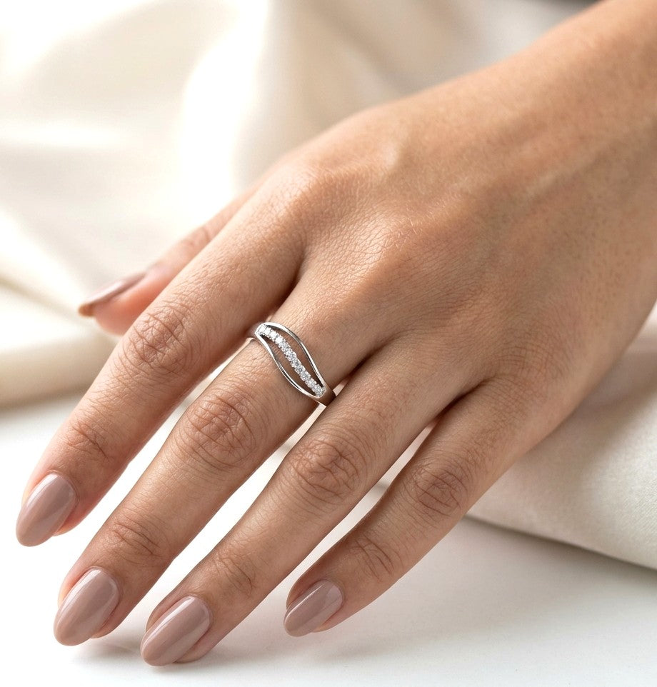 18K white gold diamond wave ring with a curved row of round diamonds and flowing polished gold design