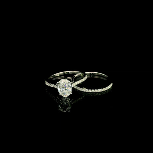 Oval cut diamond bridal set in 18K white gold featuring a GIA certified 1.50 carat natural oval diamond with matching diamond wedding band.