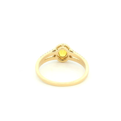 Natural yellow sapphire halo ring in 18K yellow gold featuring a 0.58 carat oval yellow sapphire with a split shank and 0.26 carat natural diamonds.