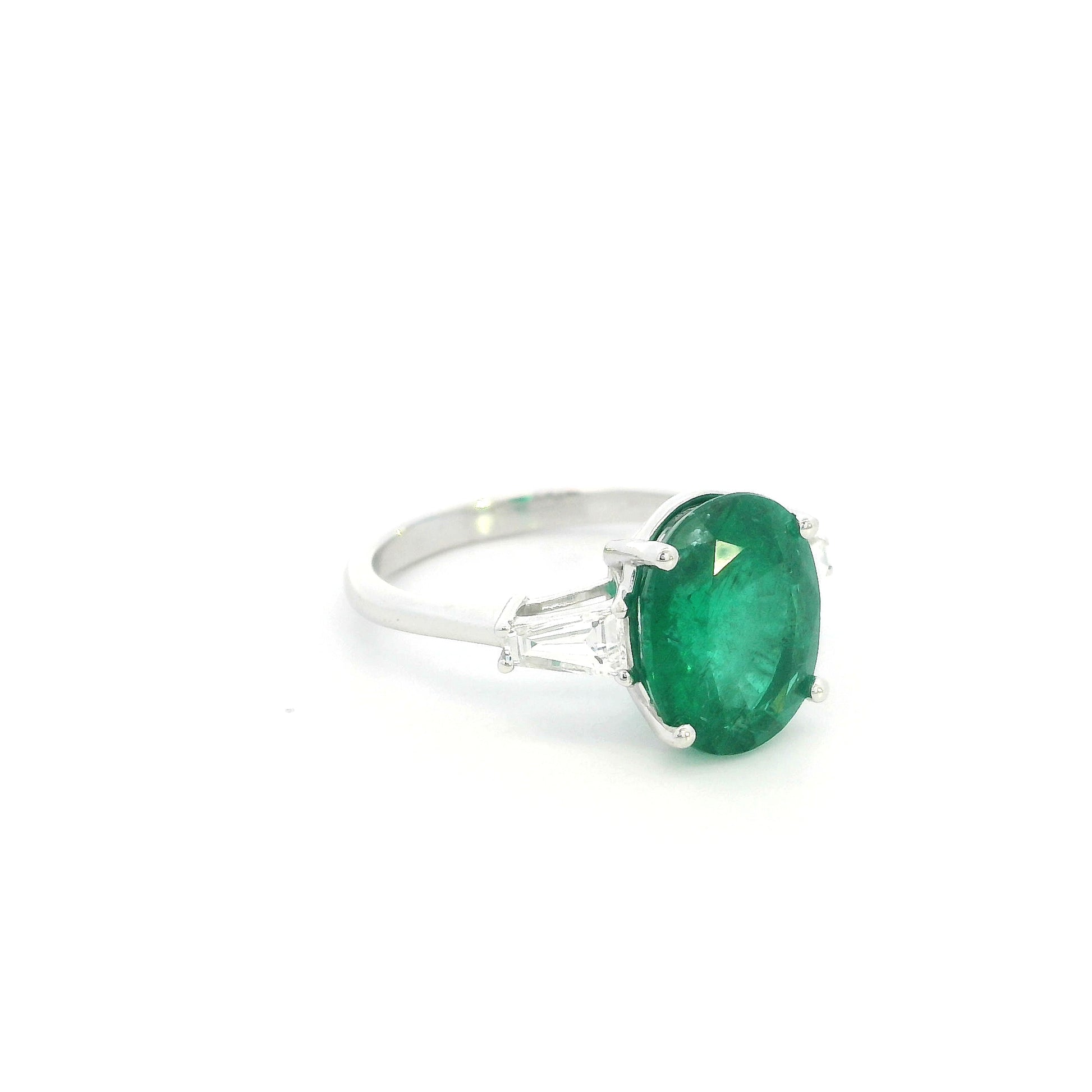 Natural oval emerald and tapered baguette diamond three stone ring in 18K white gold with a 4.03 carat centre emerald.
