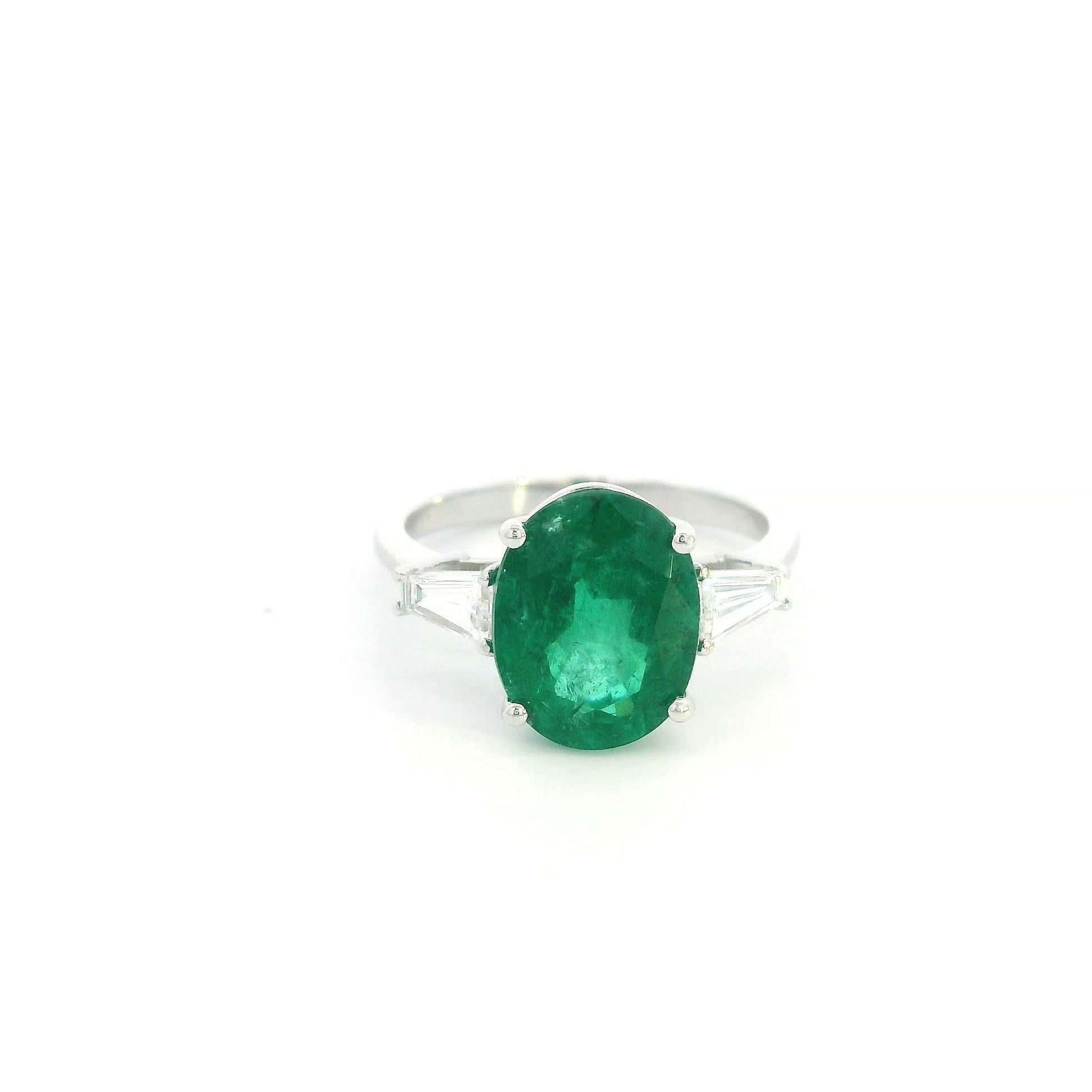 Natural oval emerald and tapered baguette diamond three stone ring in 18K white gold with a 4.03 carat centre emerald.