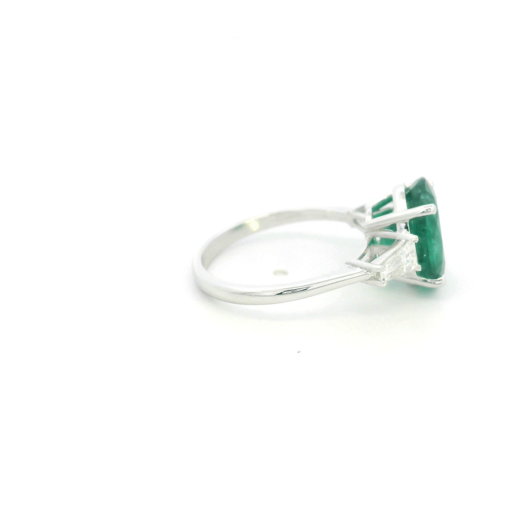 Natural oval emerald and tapered baguette diamond three stone ring in 18K white gold with a 4.03 carat centre emerald.