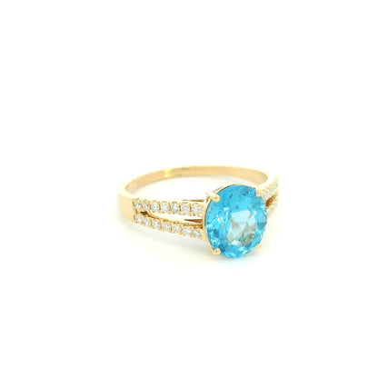 18K yellow gold Swiss blue topaz ring with oval centre stone and double-row diamond split shoulders.