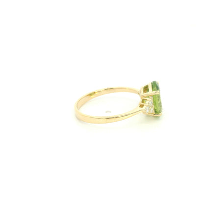 18K yellow gold peridot and diamond ring with oval green centre stone and diamond side accents.