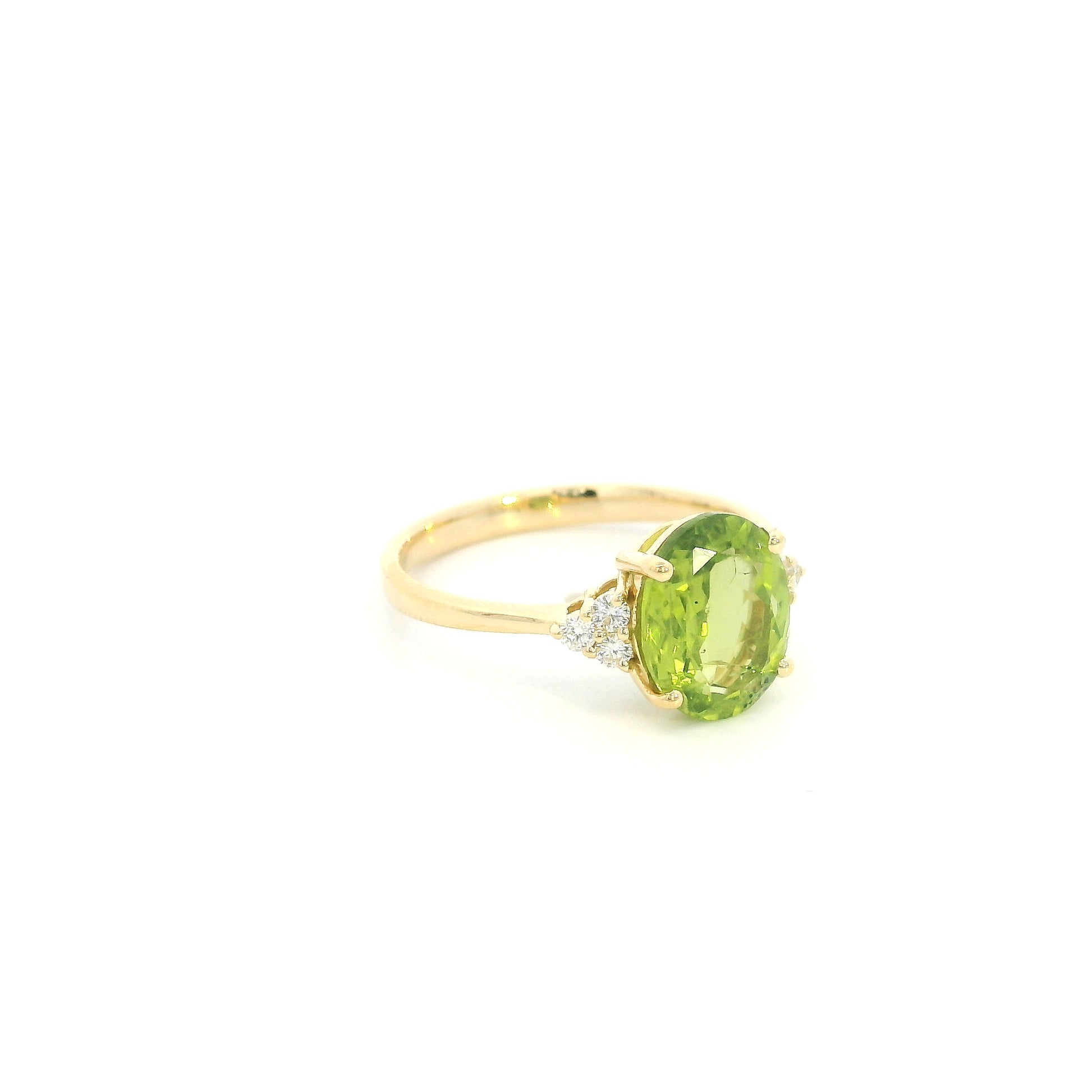 18K yellow gold peridot and diamond ring with oval green centre stone and diamond side accents.