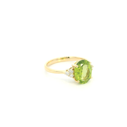 18K yellow gold peridot and diamond ring with oval green centre stone and diamond side accents.