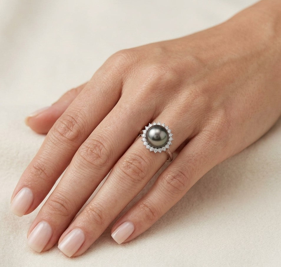 South Sea black pearl and diamond halo ring in 18K white gold featuring a lustrous dark pearl surrounded by round brilliant diamonds.