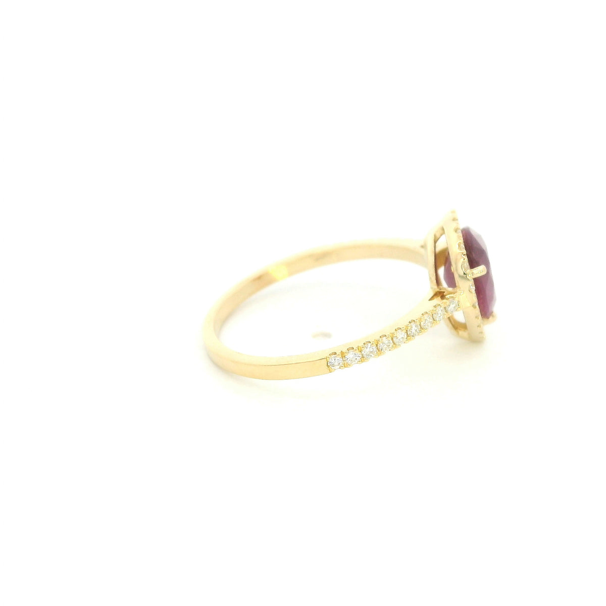 Pear shaped ruby and diamond halo ring in 18K yellow gold with diamond-set shoulders