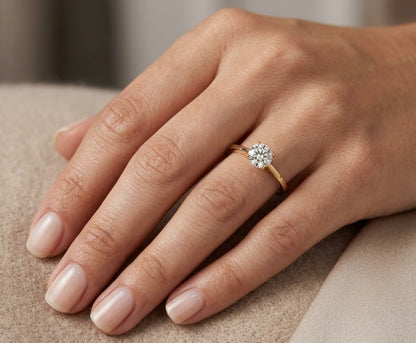 Round diamond solitaire engagement ring in 18K yellow gold with four-prong setting and tapered band