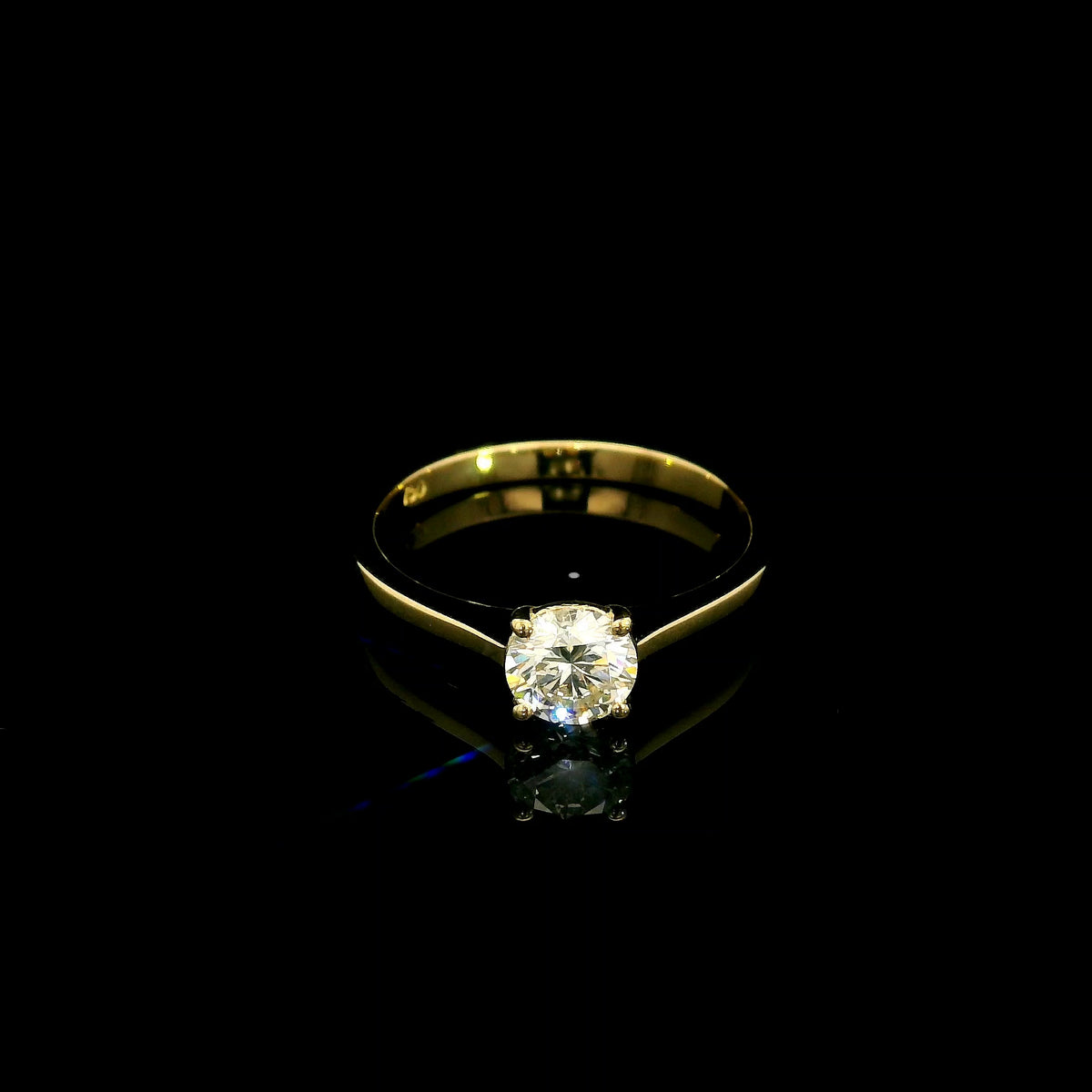 Round diamond solitaire engagement ring in 18K yellow gold with four-prong setting and tapered band