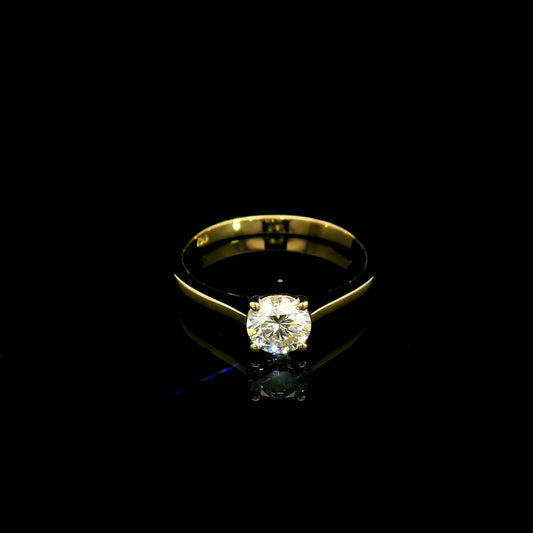 Round diamond solitaire engagement ring in 18K yellow gold with four-prong setting and tapered band