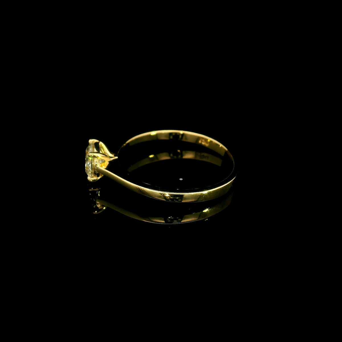 Round diamond solitaire engagement ring in 18K yellow gold with four-prong setting and tapered band