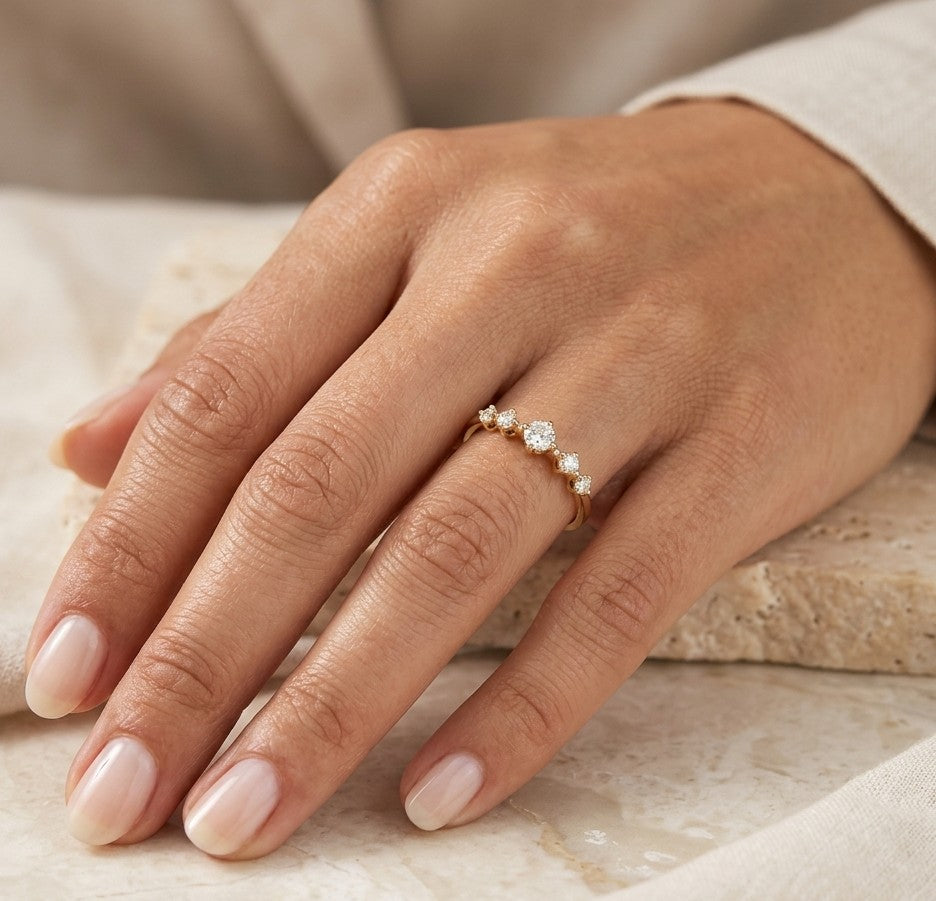 Diamond band ring in 18K rose gold with graduated round brilliant diamonds and larger centre diamond