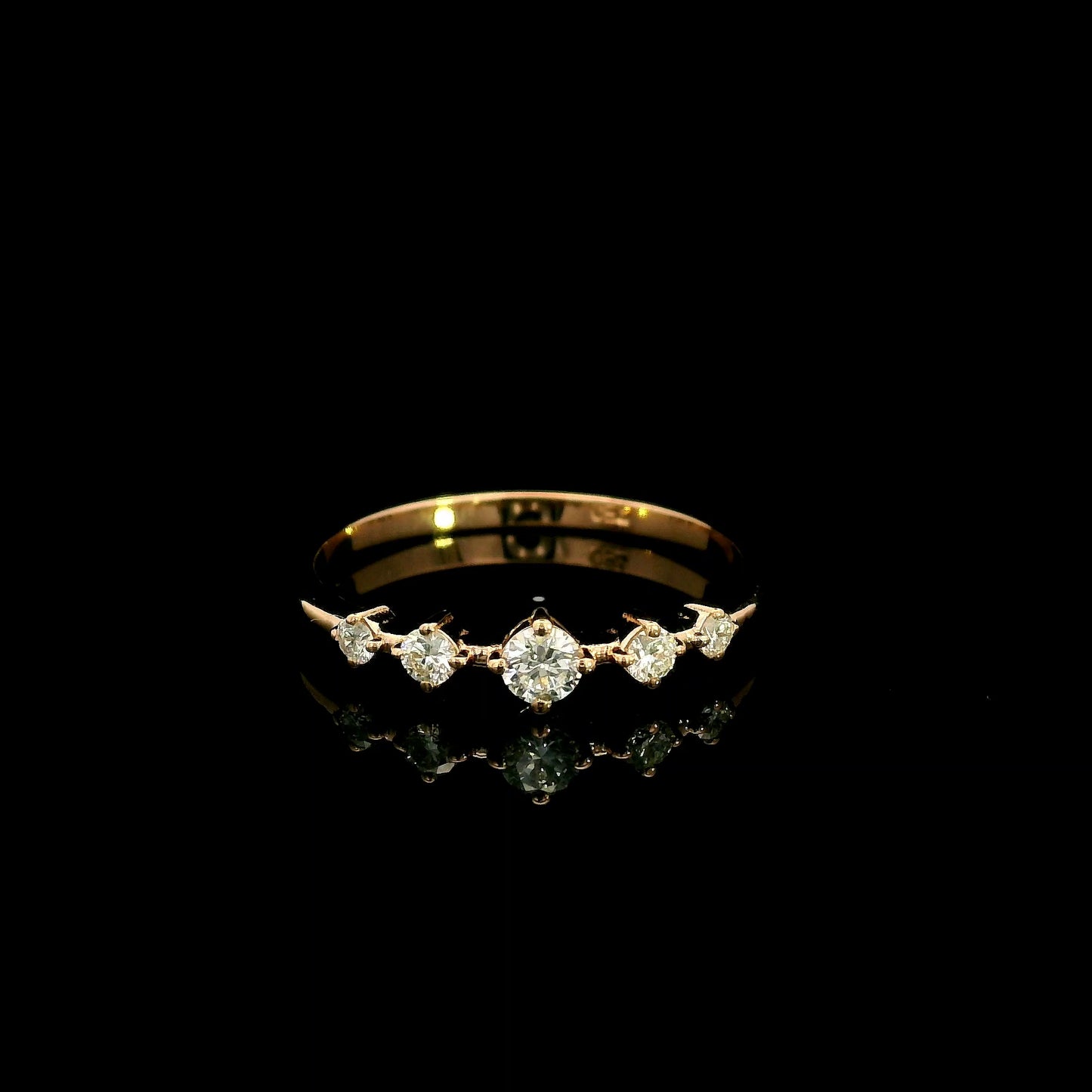 Diamond band ring in 18K rose gold with graduated round brilliant diamonds and larger centre diamond