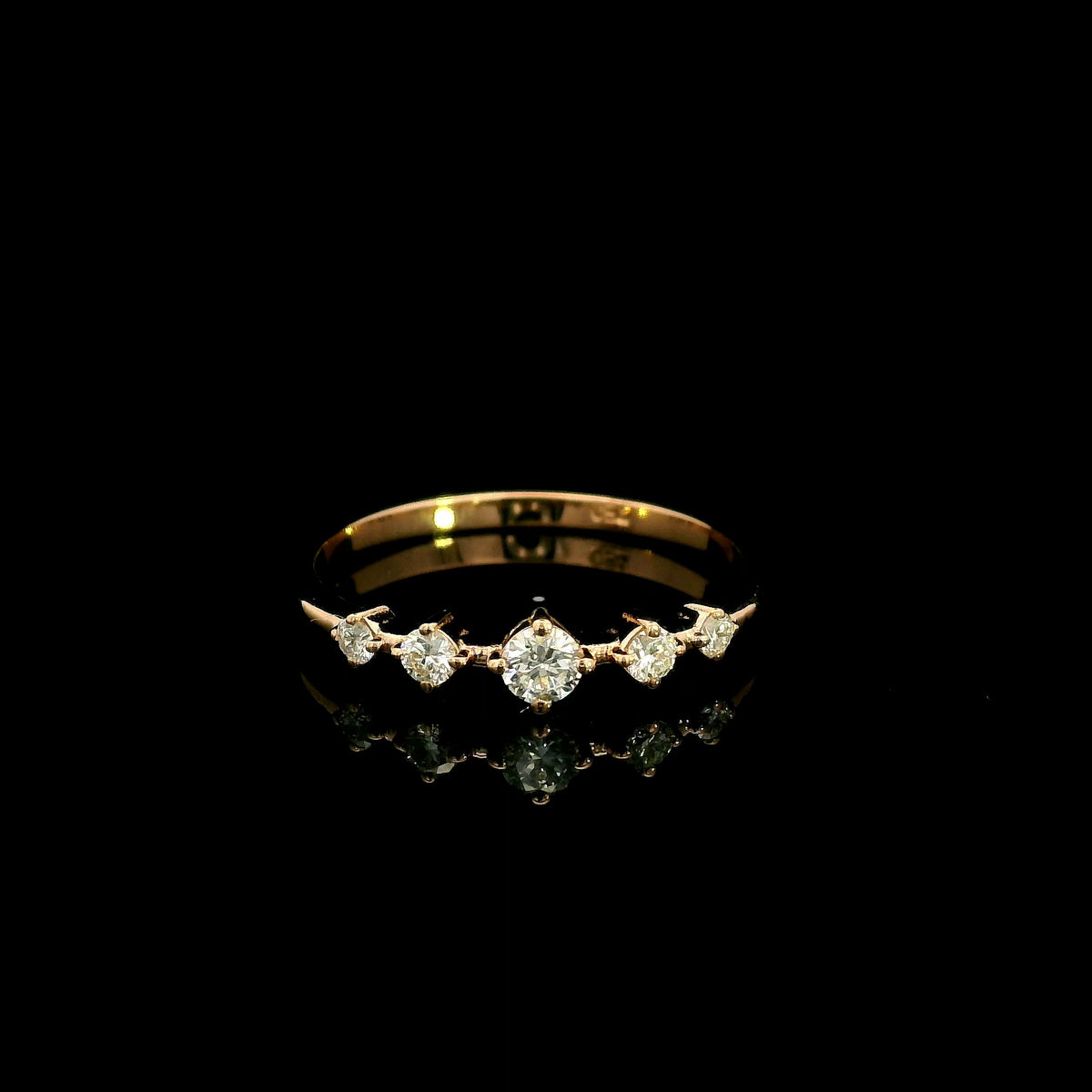 Diamond band ring in 18K rose gold with graduated round brilliant diamonds and larger centre diamond