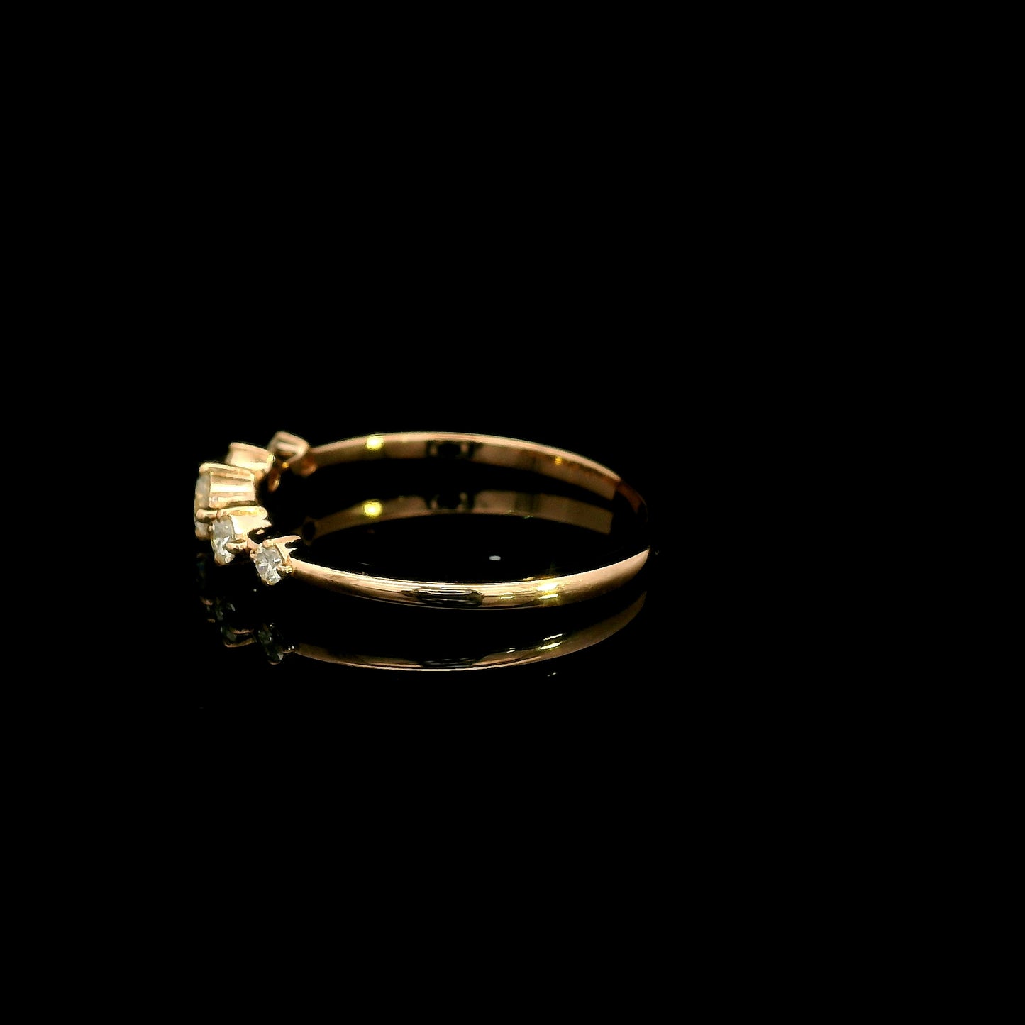 Diamond band ring in 18K rose gold with graduated round brilliant diamonds and larger centre diamond