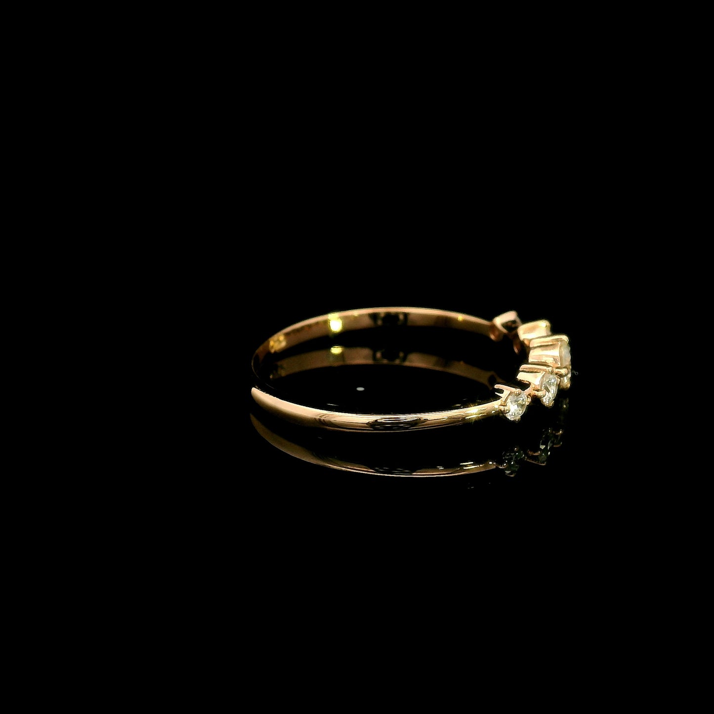 Diamond band ring in 18K rose gold with graduated round brilliant diamonds and larger centre diamond