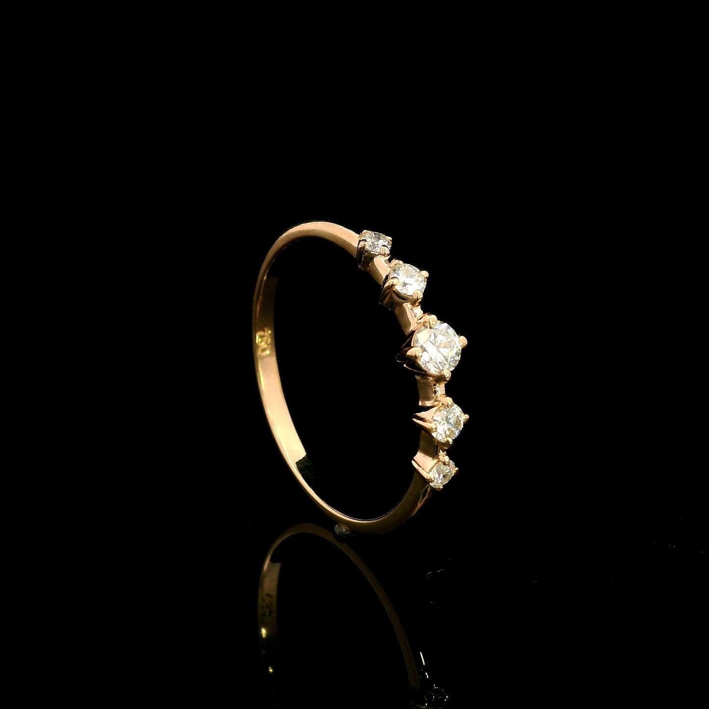 Diamond band ring in 18K rose gold with graduated round brilliant diamonds and larger centre diamond