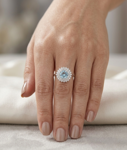 Round aquamarine and diamond double halo ring in 18K white gold with a 1.52 carat natural aquamarine.
