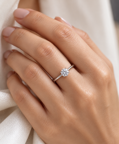 Round brilliant cut diamond solitaire engagement ring in 18K white gold featuring a 0.50 carat natural diamond in a six-prong setting on a slim polished band.