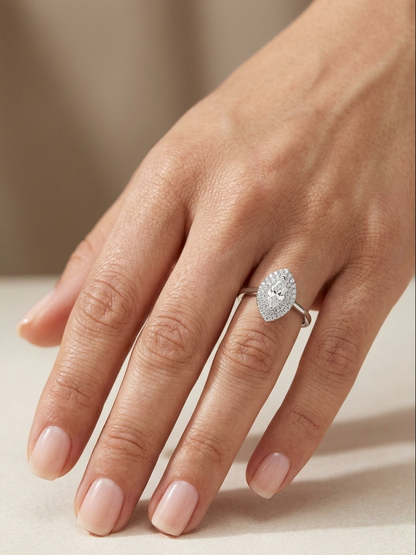 Marquise diamond halo engagement ring in 18K white gold with a marquise centre diamond surrounded by a sparkling diamond halo.
